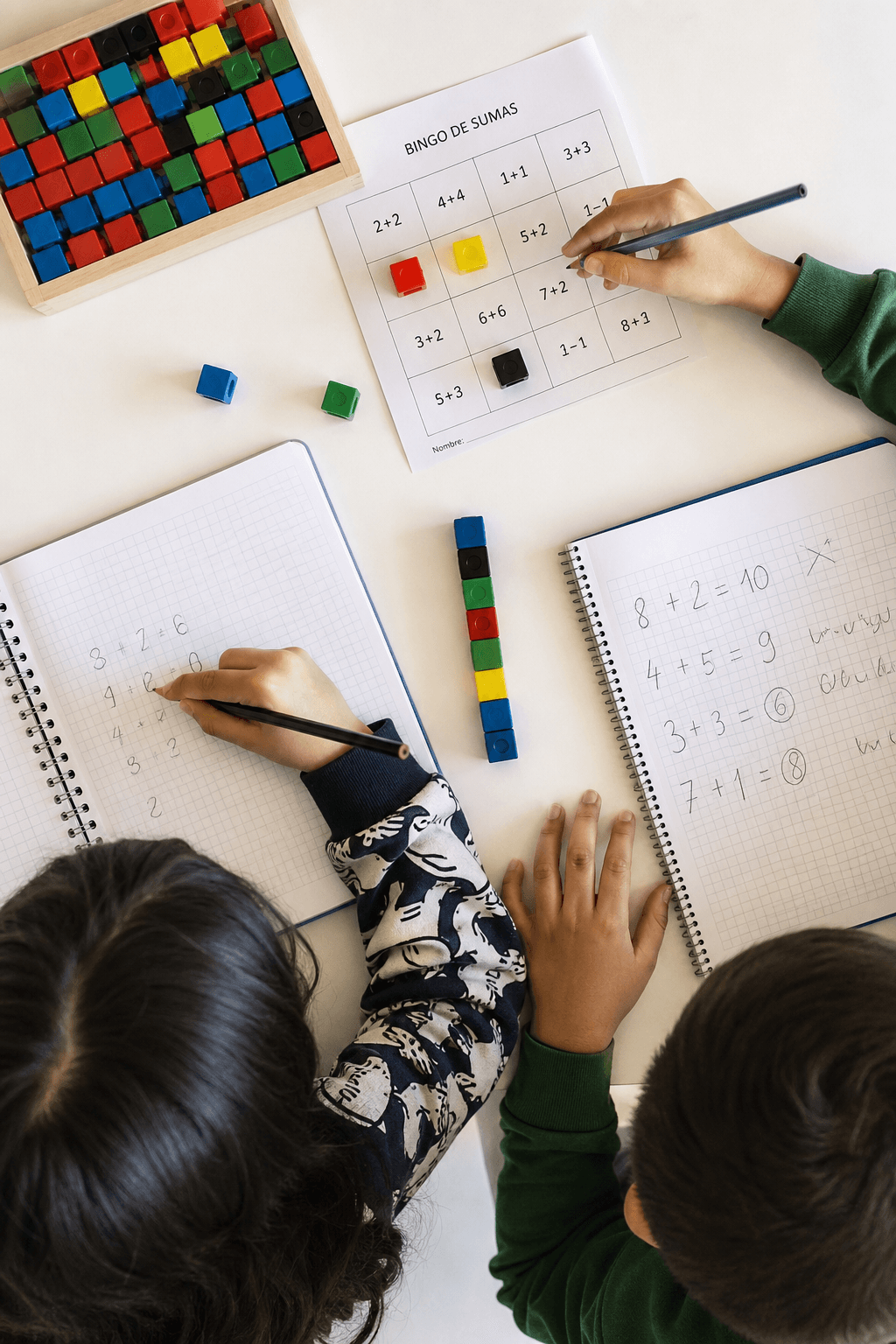 Manos de niños construyendo con cubos coloridos mientras resuelven matemáticas