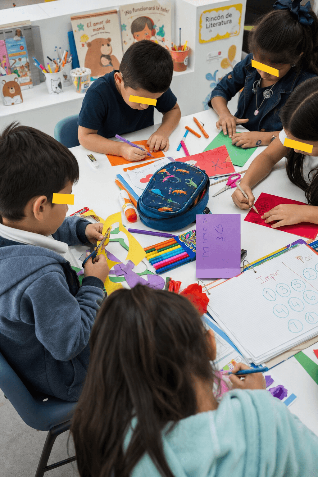 Manos creando arte con crayones y papel de colores